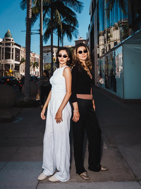 Two women posing on Rodeo Drive in Beverly Hills wearing black and white outfits
