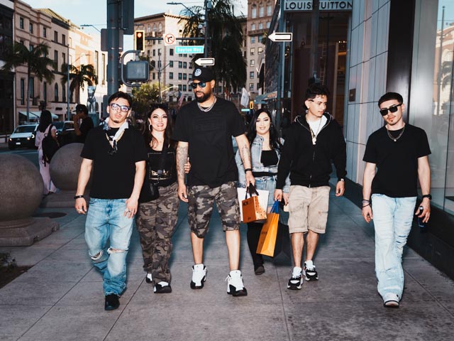 Group of people walking on Rodeo Drive near Louis Vuitton store in Beverly Hills